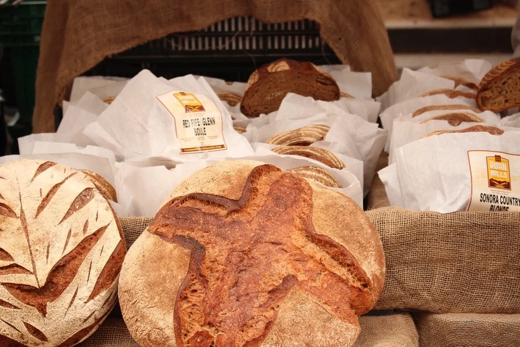 Round loaves of crusty bread in paper at a bakery