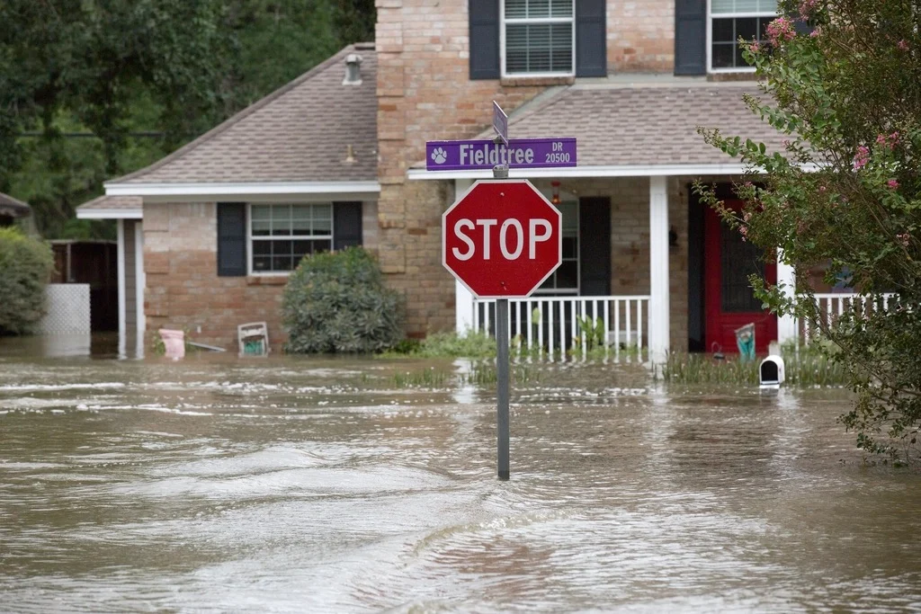 A stop sign standing in a flooded residential street