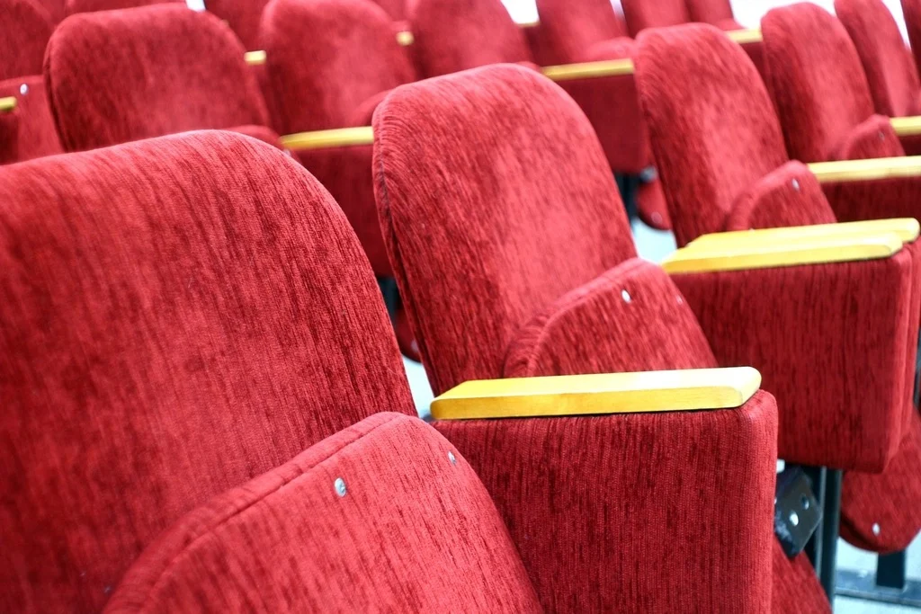 Rows of red upholstered theater seats