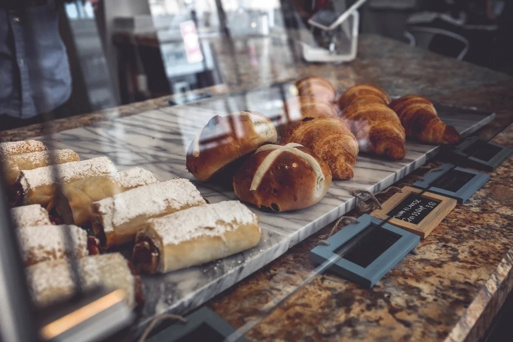 Croissants and pastries behind a bakery counter window